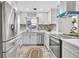 Modern kitchen boasts white cabinets, stainless steel appliances, marble backsplash, and a sleek design at 1384 S Hillcrest Ave, Clearwater, FL 33756