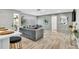 Cozy living room with stylish gray sofa, decorative mirrors, and wood-look flooring at 1384 S Hillcrest Ave, Clearwater, FL 33756