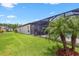 Beautiful backyard with lush green grass, manicured landscaping, and a screened lanai and pool at 14514 Woodland Spur Dr, Lithia, FL 33547