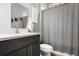 Well-lit bathroom featuring a modern vanity, framed mirror, and striped shower curtain at 14514 Woodland Spur Dr, Lithia, FL 33547