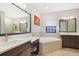 This bathroom features dual vanities, a soaking tub and a makeup area at 14514 Woodland Spur Dr, Lithia, FL 33547