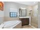 This bathroom features a soaking tub, glass-enclosed shower and a marble vanity at 14514 Woodland Spur Dr, Lithia, FL 33547