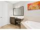 This bathroom features a soaking tub and a marble vanity with a makeup area at 14514 Woodland Spur Dr, Lithia, FL 33547