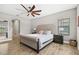 This bedroom features stylish wood-look tile floors, a neutral color palette and a tufted headboard at 14514 Woodland Spur Dr, Lithia, FL 33547