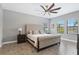 This bedroom features stylish wood-look tile floors, a neutral color palette and a tufted headboard at 14514 Woodland Spur Dr, Lithia, FL 33547