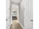 Hallway view leading into the bathroom featuring wood look floors and neutral paint at 14514 Woodland Spur Dr, Lithia, FL 33547