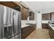 View of the modern kitchen featuring stainless steel refrigerator and gas range with wood cabinets at 14514 Woodland Spur Dr, Lithia, FL 33547