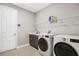 Functional laundry room featuring a washing machine, dryer, and storage shelves at 14514 Woodland Spur Dr, Lithia, FL 33547