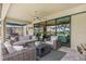 Covered patio featuring stylish outdoor furniture and views of the lush backyard and lake at 14514 Woodland Spur Dr, Lithia, FL 33547