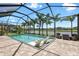 Beautiful screened pool with relaxing chairs and a lovely lake view surrounded by palm trees at 14514 Woodland Spur Dr, Lithia, FL 33547