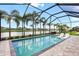 Beautiful screened pool with relaxing chairs and a lovely lake view surrounded by palm trees at 14514 Woodland Spur Dr, Lithia, FL 33547