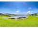 Beautiful backyard view showcasing a tranquil lake and grassy lawn, ideal for enjoying the outdoors at 15505 Wicked Strong St, Sun City Center, FL 33573