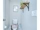 Cozy bathroom with toilet, decorative wall art, wood shelf with metal brackets, and neutral wall color at 15505 Wicked Strong St, Sun City Center, FL 33573