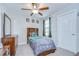 Bedroom featuring a bed, window, dresser, and ceiling fan; perfect for relaxation and comfort at 15505 Wicked Strong St, Sun City Center, FL 33573