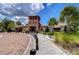 Elegant community clubhouse entrance with brick path, palm trees, and landscaping, highlighting a welcoming and recreational space at 15505 Wicked Strong St, Sun City Center, FL 33573