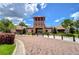 Beautiful community clubhouse entrance with a tower and landscaping, showcasing the neighborhood's amenities and welcoming atmosphere at 15505 Wicked Strong St, Sun City Center, FL 33573