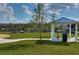 View of the community dog park with blue shaded picnic area with benches and equipment to train the dogs on at 15505 Wicked Strong St, Sun City Center, FL 33573