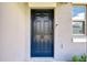 Close-up of the elegant, dark blue front door with digital lock hardware and welcome mat at 15505 Wicked Strong St, Sun City Center, FL 33573
