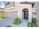 A gray stucco house showcasing an arched entry and gray garage door at 15505 Wicked Strong St, Sun City Center, FL 33573