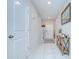 Bright and airy hallway featuring tile floors, white trim, and stylish decor at 15505 Wicked Strong St, Sun City Center, FL 33573