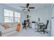 Home office with large window, ceiling fan, computer desks, rolling chairs, and comfortable couch at 15505 Wicked Strong St, Sun City Center, FL 33573