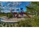 Exterior shot of the neighborhood playground with colorful equipment, mulch base, lush greenery and clear blue skies at 15505 Wicked Strong St, Sun City Center, FL 33573