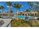 Resort-style community pool area with sun loungers, palm trees, and a covered pavilion offering luxurious relaxation at 15505 Wicked Strong St, Sun City Center, FL 33573
