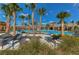 Relaxing community pool features lounge chairs, swaying palms, and a nearby pergola, perfect for a sunny retreat at 15505 Wicked Strong St, Sun City Center, FL 33573
