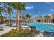View of the community pool with clear blue water, palm trees, lounge chairs and a shaded cabana at 15505 Wicked Strong St, Sun City Center, FL 33573