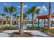 Exterior shot of the community pool with lounge chairs, clear blue skies, and palm trees at 15505 Wicked Strong St, Sun City Center, FL 33573