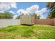 A fenced backyard showcases a versatile shed set on a lush lawn, ideal for storage or hobbies at 1621 Crossridge Dr, Brandon, FL 33510