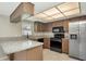 Modern kitchen with stainless steel appliances, granite counters, and warm wood cabinetry at 1621 Crossridge Dr, Brandon, FL 33510