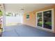 A covered patio offers a smooth concrete base, privacy fence, and a slider leading to the green backyard space at 1621 Crossridge Dr, Brandon, FL 33510