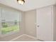 Bright room featuring tile flooring, a window with blinds, base trim and a standard door at 1621 Crossridge Dr, Brandon, FL 33510