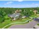 Stunning aerial view of a single-story home with mature landscaping, a screened-in pool, and a circular driveway at 17311 Carriage Way, Odessa, FL 33556