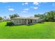 Expansive backyard with lush green grass and views of the home's rear exterior at 17311 Carriage Way, Odessa, FL 33556