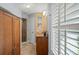 Well-lit bathroom featuring tile flooring, wooden cabinets, and a glass-enclosed shower with colorful mosaic wall art at 17311 Carriage Way, Odessa, FL 33556