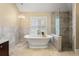 Spa bathroom features a soaking tub, glass shower, and travertine tile at 17311 Carriage Way, Odessa, FL 33556