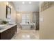 Luxurious bathroom featuring double sinks, soaking tub, and tiled shower at 17311 Carriage Way, Odessa, FL 33556