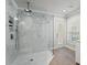 Modern bathroom featuring a large glass shower with a rainfall showerhead and marble-style tile at 17311 Carriage Way, Odessa, FL 33556