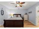 Cozy bedroom with hardwood floors, a ceiling fan, and ample natural light from the window at 17311 Carriage Way, Odessa, FL 33556