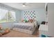 Bright bedroom featuring a large window, ceiling fan, and built-in bed with ample storage underneath at 17311 Carriage Way, Odessa, FL 33556