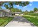 Charming single-story home boasts a lush front yard and long driveway leading to a two-car garage at 17311 Carriage Way, Odessa, FL 33556