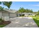 Spacious home with a three-car garage, a wide driveway, and a palm tree in the front yard at 17311 Carriage Way, Odessa, FL 33556