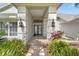 Inviting front entrance with elegant double doors, columns, and beautifully landscaped flower beds at 17311 Carriage Way, Odessa, FL 33556