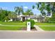 Well-manicured front exterior of a single-story home with a lush lawn, mature trees, and a welcoming entrance at 17311 Carriage Way, Odessa, FL 33556