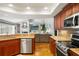 Open-concept kitchen with stainless steel appliances, granite countertops, and dark wood cabinetry at 17311 Carriage Way, Odessa, FL 33556