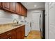 Practical laundry room featuring granite countertops and overhead cabinet storage at 17311 Carriage Way, Odessa, FL 33556