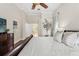 Comfortable main bedroom features a ceiling fan, neutral walls, hardwood floors, and an ensuite bath at 17311 Carriage Way, Odessa, FL 33556