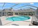 A screened-in pool with attached hot tub, and an outdoor kitchen at 17311 Carriage Way, Odessa, FL 33556